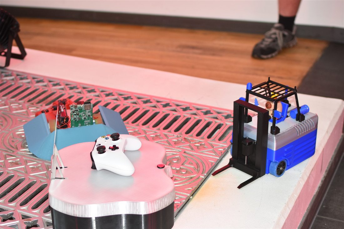 Drei sehr unterschiedliche Sumobots mit Controllern an der Arena