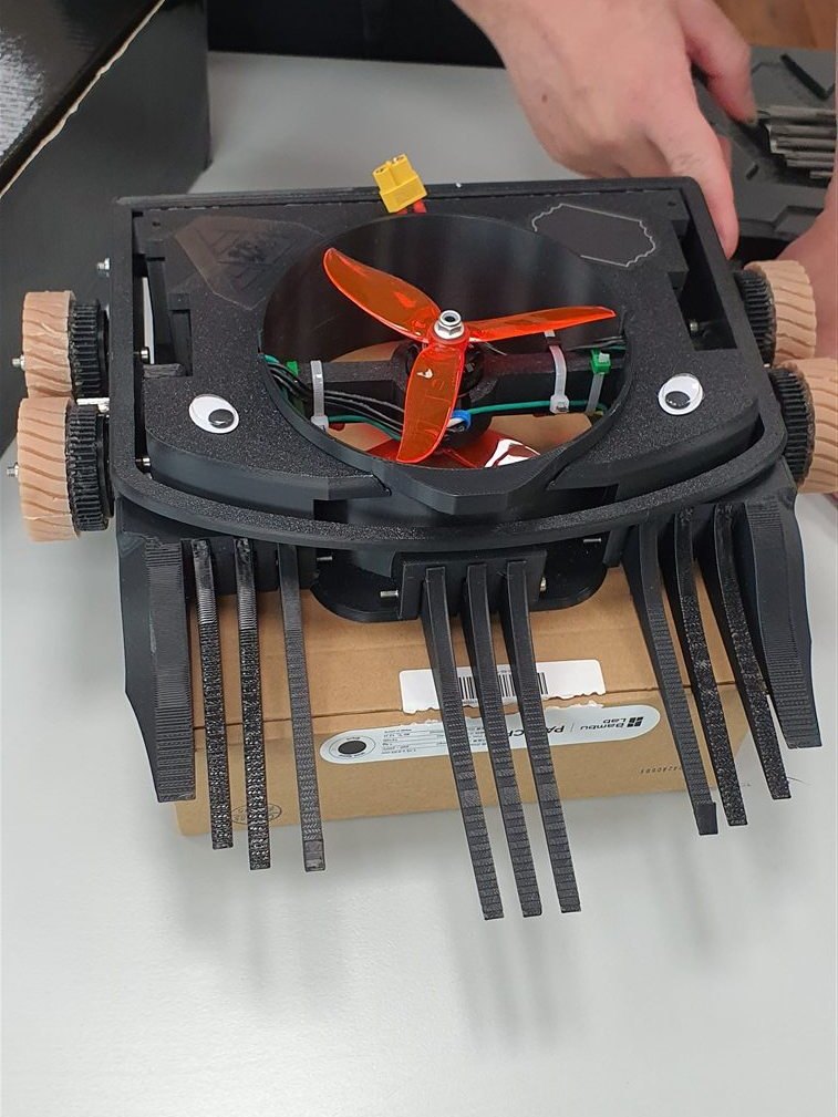 Schwarzer Propeller-Bot mit mehreren flexiblen Frontzinken