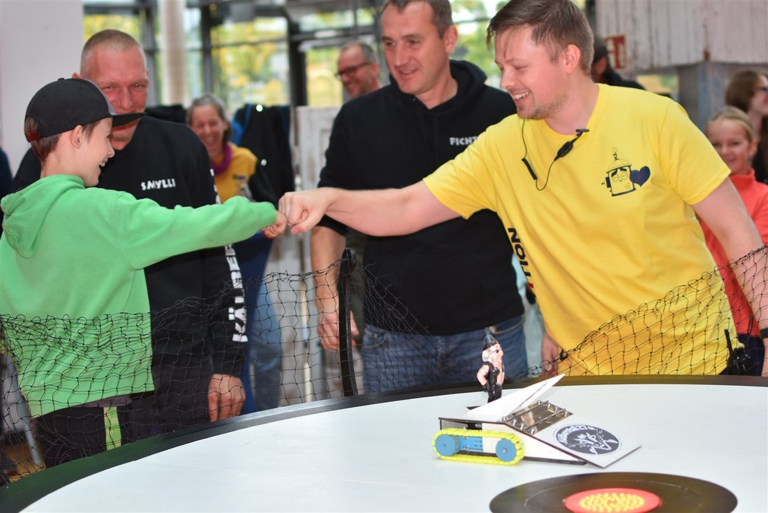 Zwei Teams gratulieren sich nach einem Sumobot-Kampf